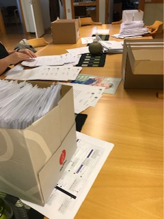 Fakturor som stoppas i kuvert på ett skrivbord.