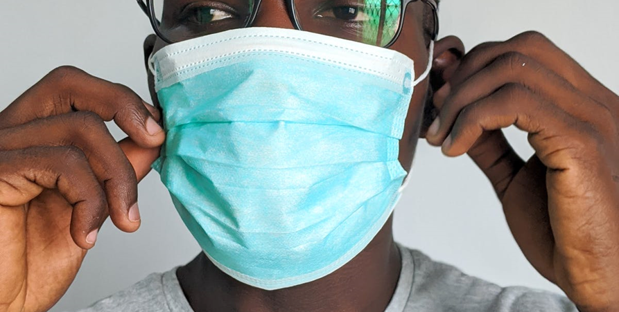 Närbild på person med munskydd.