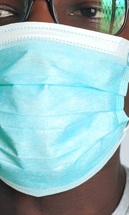 Närbild på person med munskydd.